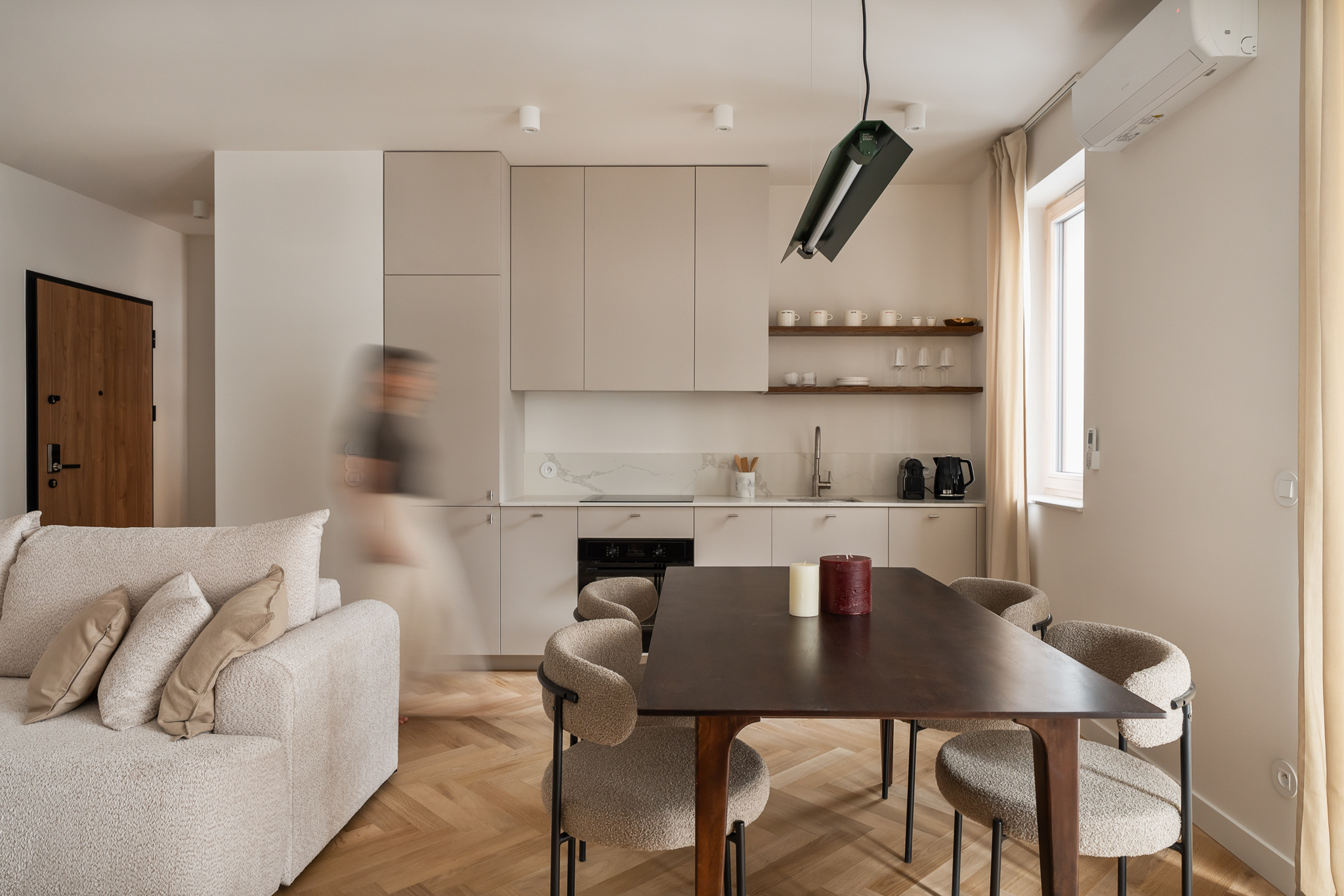 beżowa kuchnia z przechodzącą przez nią postacią